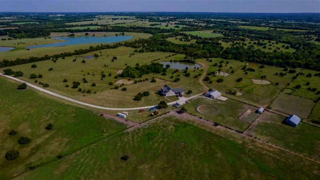 Aerial view of pasture, ponds, and barns across the land
